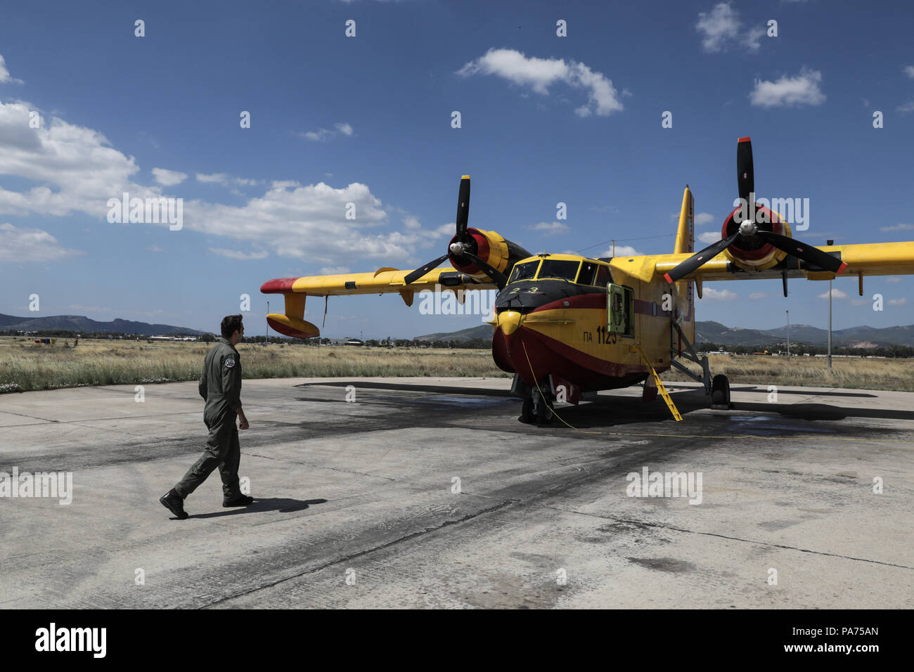 Athens, Greece. 20th July, 2018. Pilot Georgios Apostolou walks to a Canadair firefighting aircraft at Elefsina Air Base, Athens, Greece, on July 20, 2018. The 355 Tactical Transport Squadron was established in 1947 to fight wildfires. Credit: Lefteris Partsalis/Xinhua/Alamy Live News Stock Photo