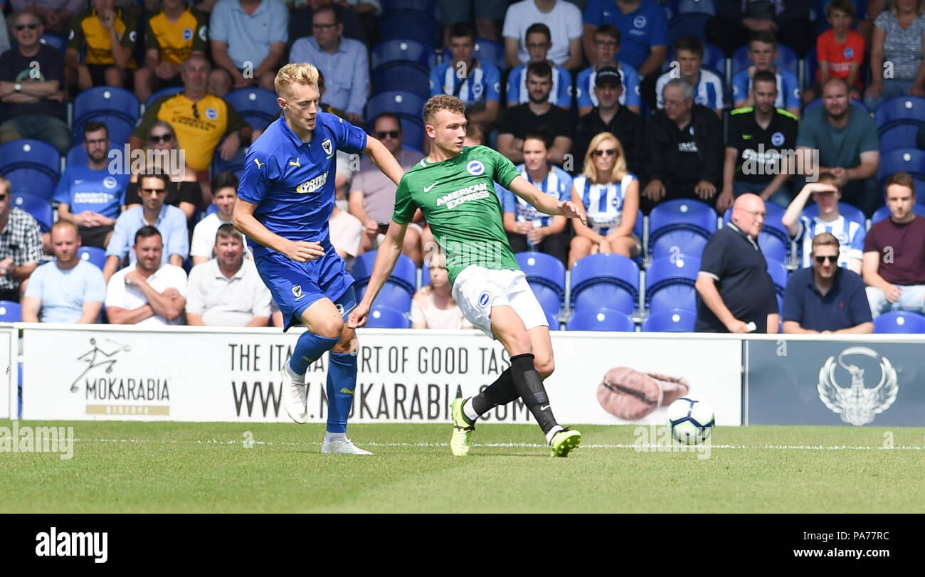 Kingston London UK 21st July 2018 - Ben Barclay (right)  of Brighton clears the ball away from Joe Pigott of Wimbledon during the pre season friendly football match between AFC Wimbledon and Brighton and Hove Albion  at the Cherry Red Records Stadium in Kingston Surrey Photograph taken by Simon Dack Credit: Simon Dack/Alamy Live News - Editorial Use Only Stock Photo