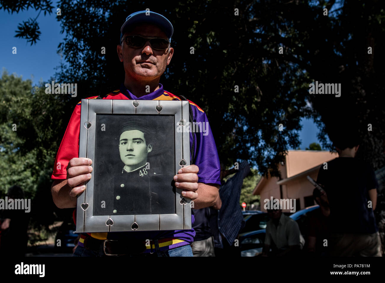 San Lorenzo del Escorial, Madrid, Spain. 21st July 2018. A man wearing the republican colors posing with a picture of his grandfather who was killed by Franco's army in Malaga during the Spanish civil war. People have protested at the entrance of 'Valle de los Caidos' (Valley of the Fallen) monument to demand the removal of Franco and Primo de Rivera's remains, in San Lorenzo del Escorial, Madrid, Spain. Credit: Marcos del Mazo/Almy Live News Stock Photo
