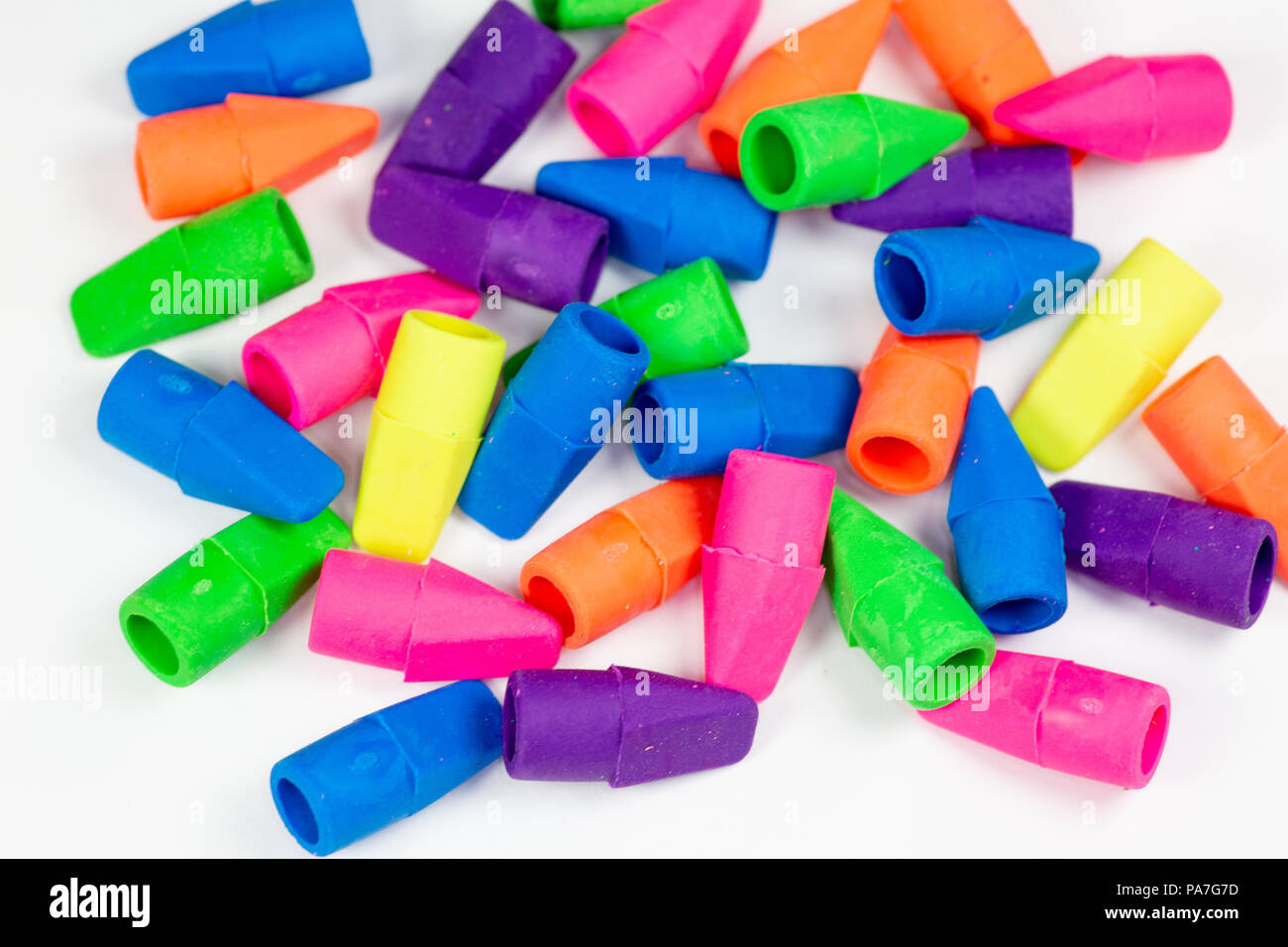 Colorful pencil erasers cluttered on a white surface Stock Photo