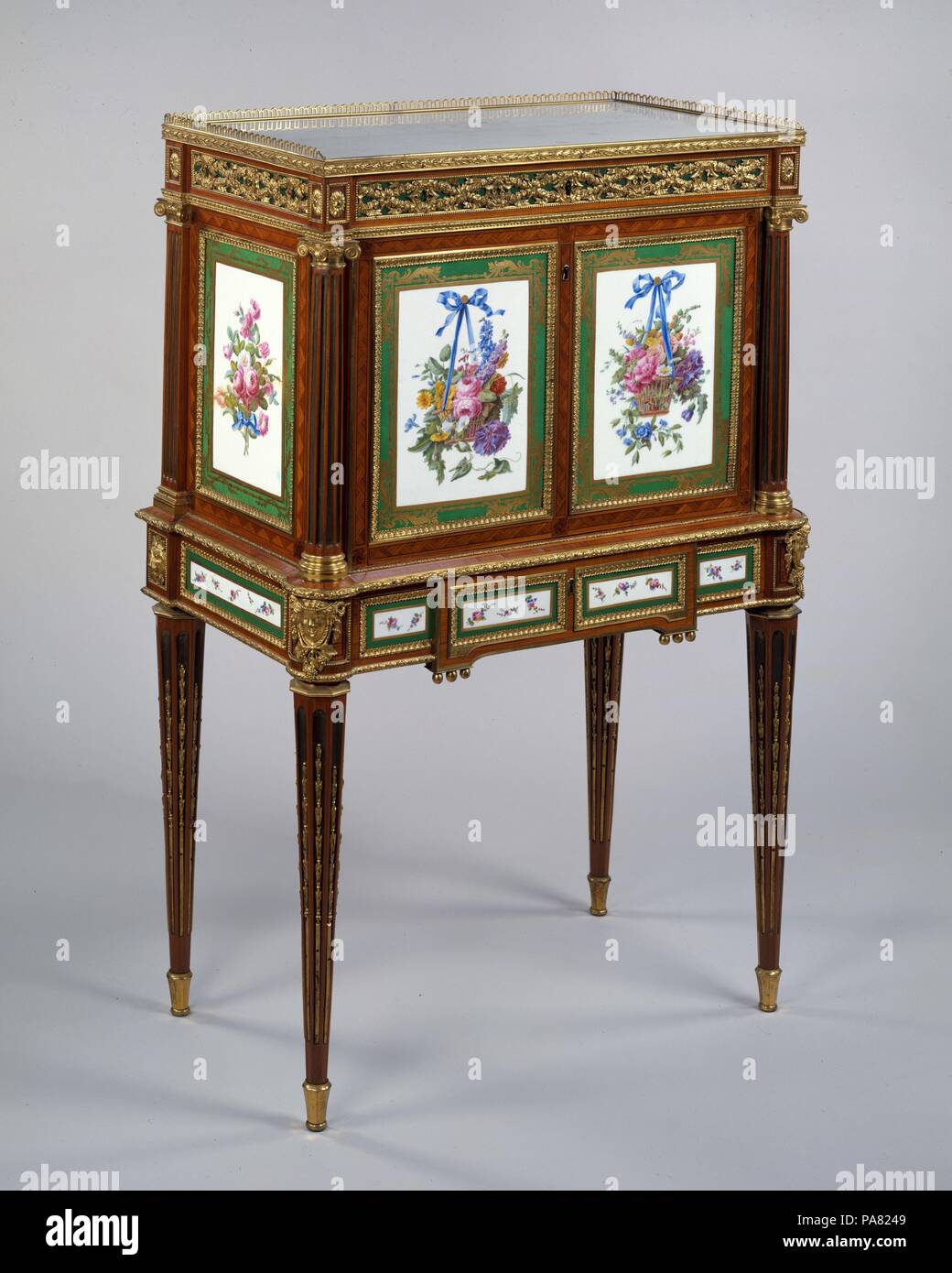Secretary. Artist: Attributed to Martin Carlin (French, near Freiburg im Breisgau ca. 1730-1785 Paris); Sèvres Manufactory (French, 1740-present) (soft-paste porcelain plaques); various French painters, Paris (soft-paste porcelain plaques). Dimensions: H. 120.3 cm, W. 80 cm, D. 45.7 cm. Date: ca. 1781-85.  This upright rectangular drop-front secrétaire is thought to have come from the Parisian workshop of the French cabinetmaker ('maitre-ébeniste') Martin Carlin. From his quarters in the Rue de Faubourg Saint-Antoine, Carlin produced writing-desks, commodes, and secretaires inset with porcelai Stock Photo