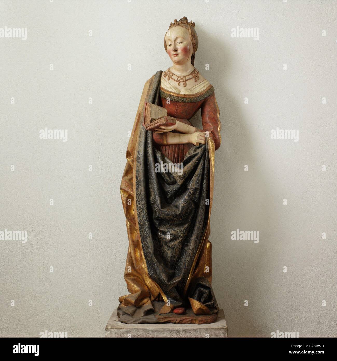 Saint Barbara. Culture: German. Dimensions: 50 1/4 × 17 × 13 1/4 in., 63 lb. (127.6 × 43.2 × 33.7 cm, 28576.613g). Date: ca. 1490.  This well-preserved figure of Saint Barbara came from the central shrine of the high altarpiece of the church of Saint Mauritius on the east side of the Rhine River, south of Strasbourg. The central shrine was dismantled prior to the early seventeenth century, and the sculptures were consigned to the charnel house in Kippenheim. The now-dispersed figures and the painted wings have survived, allowing for the reconstruction of the altarpiece. Dedicated to the Virgin Stock Photo