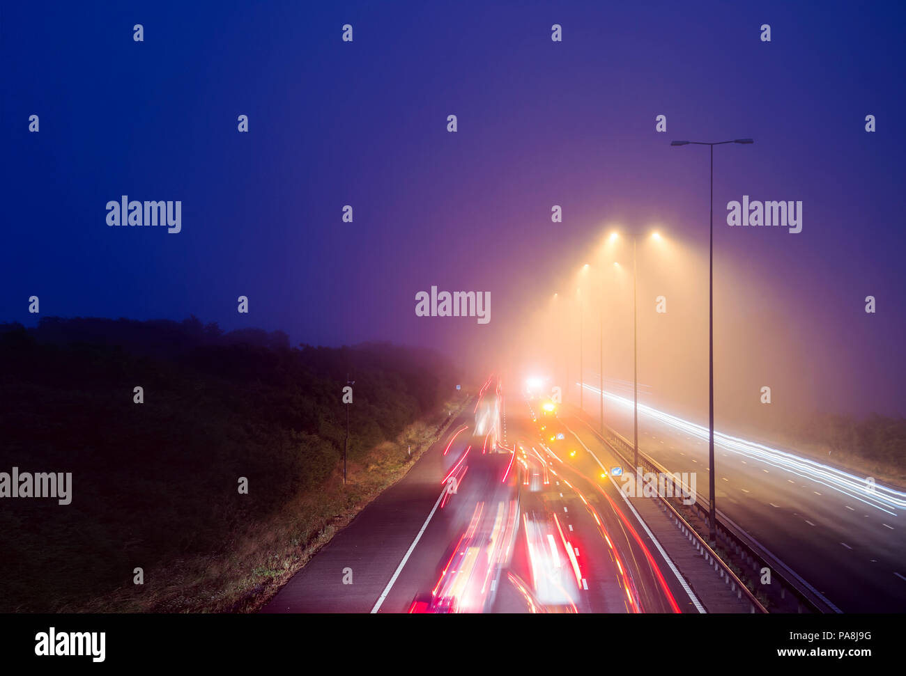 Traffic trails on a foggy night looking down on the M5 motorway Stock Photo