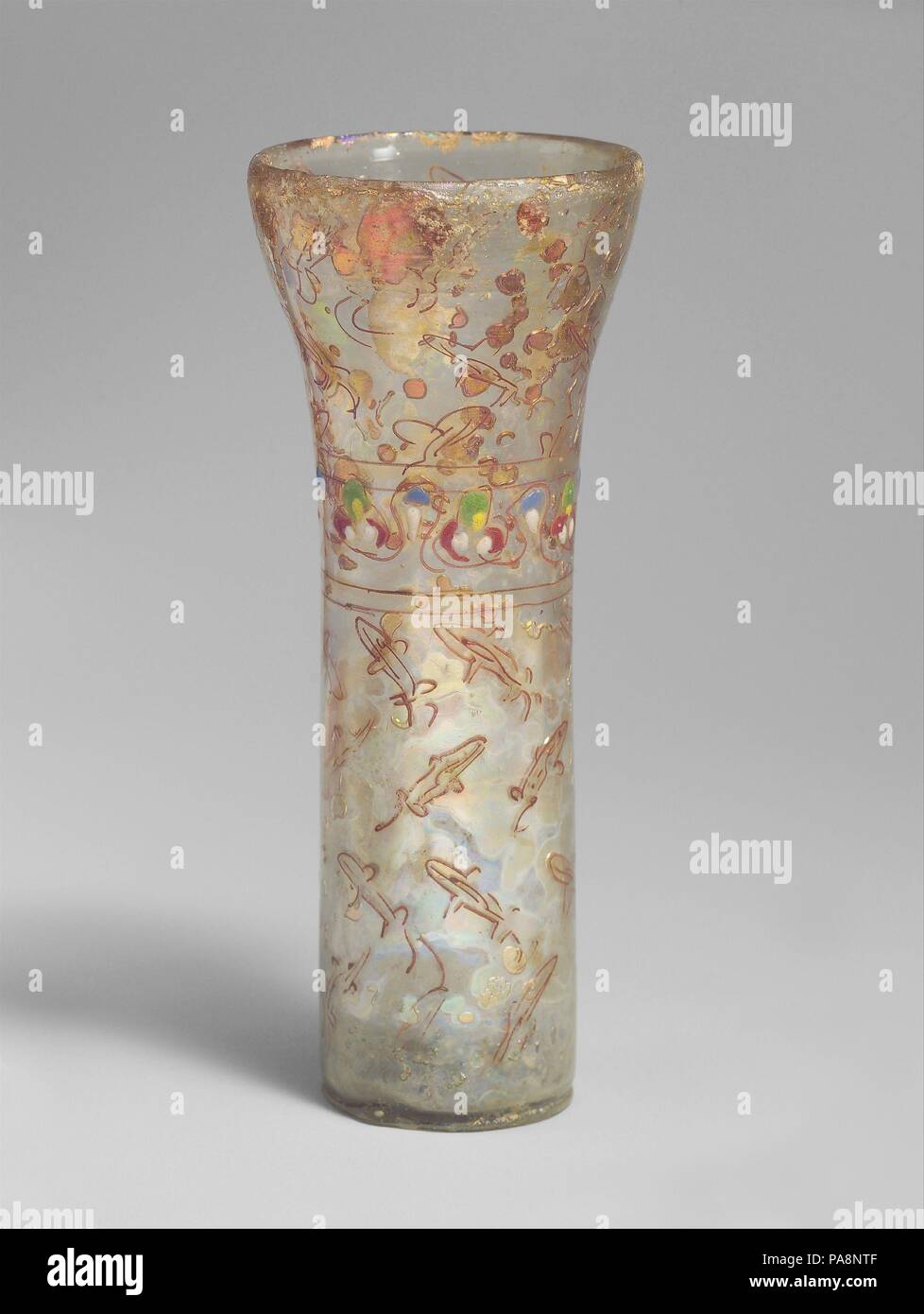 Beaker with Fish Motifs. Dimensions: H. 5 1/4 in. (13.3 cm)  Diam. 2 1/8 in. (5.4 cm). Date: 13th-14th century.  Glass decorated with contrasting colors was common in the early Islamic period and continued to be made well into the thirteenth century, as is exemplified by these marvered, enameled, and applied glass beakers. Museum: Metropolitan Museum of Art, New York, USA. Stock Photo