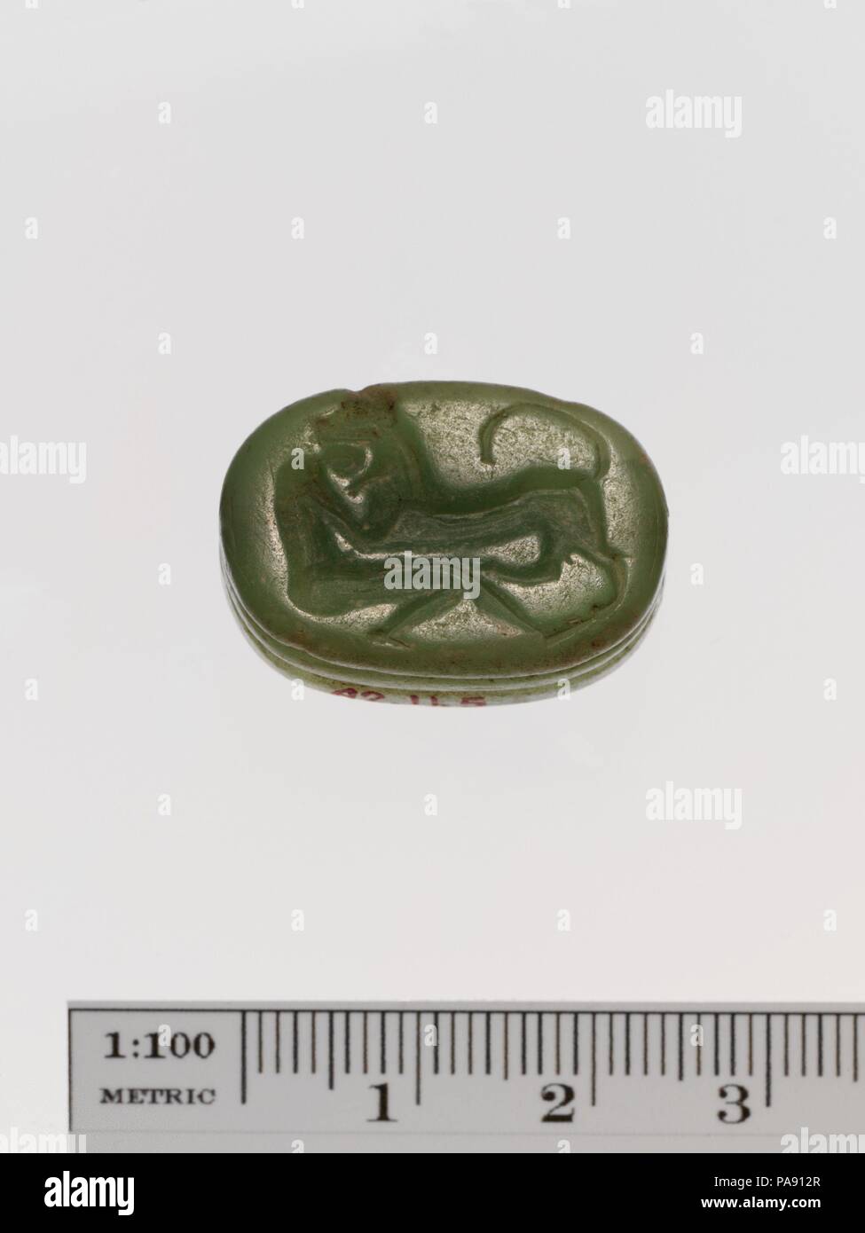 Steatite scaraboid seal. Culture: Greek. Dimensions: L. 2.5 cm. Date: early 7th century B.C..  Lion attacking man. The man's head is inside the jaws of the animal. Museum: Metropolitan Museum of Art, New York, USA. Stock Photo