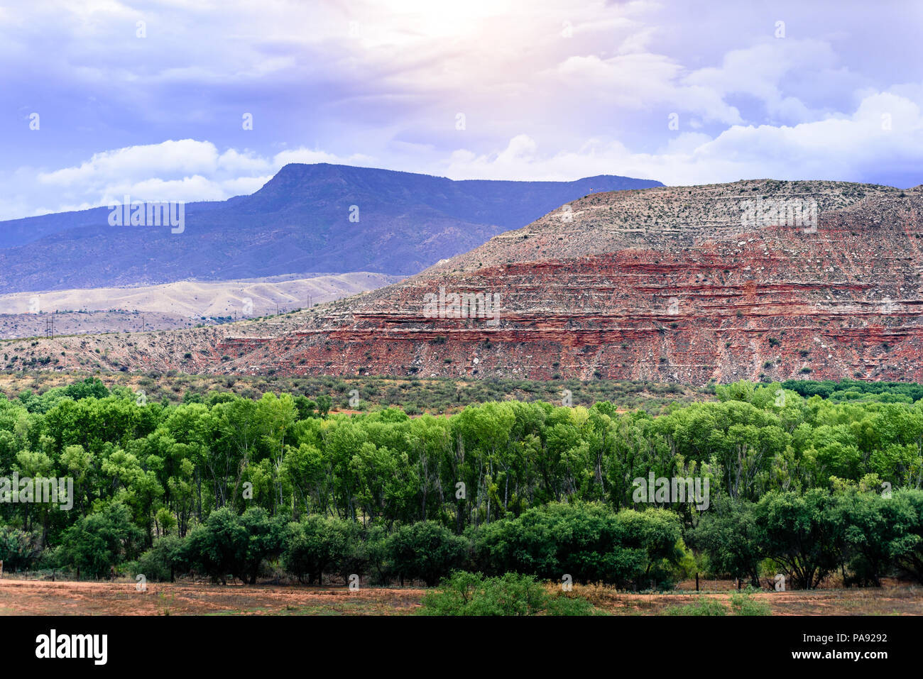 A cloudy day over a rocky mountain and lush valley. A summer monsoon gathers in the distance Stock Photo