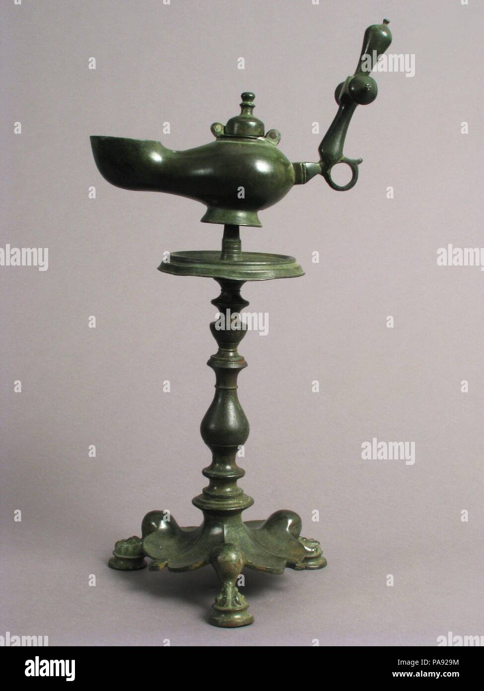 Standing Lamp with a Cross on a Pricket Stand. Culture: Byzantine. Dimensions: Overall: 17 3/16 x 8 3/8 x 6 7/16 in. (43.6 x 21.3 x 16.3 cm)  stand only: 11 11/16 x 6 7/16 in. (29.7 x 16.3 cm)  lamp only: 6 1/8 x 8 3/8 x 3 1/4 in. (15.6 x 21.3 x 8.3 cm). Date: 5th century.  Standing lamps decorated with crosses and supported on footed bases were common in the early Byzantine world. Bishop Theodoret of Cyrrhus in Syria (d. ca. 466) described Saint Symeon Stylites, who lived atop a column, as 'this dazzling lamp, [who] as if placed on a lampstand, has sent out rays in all directions likes the su Stock Photo