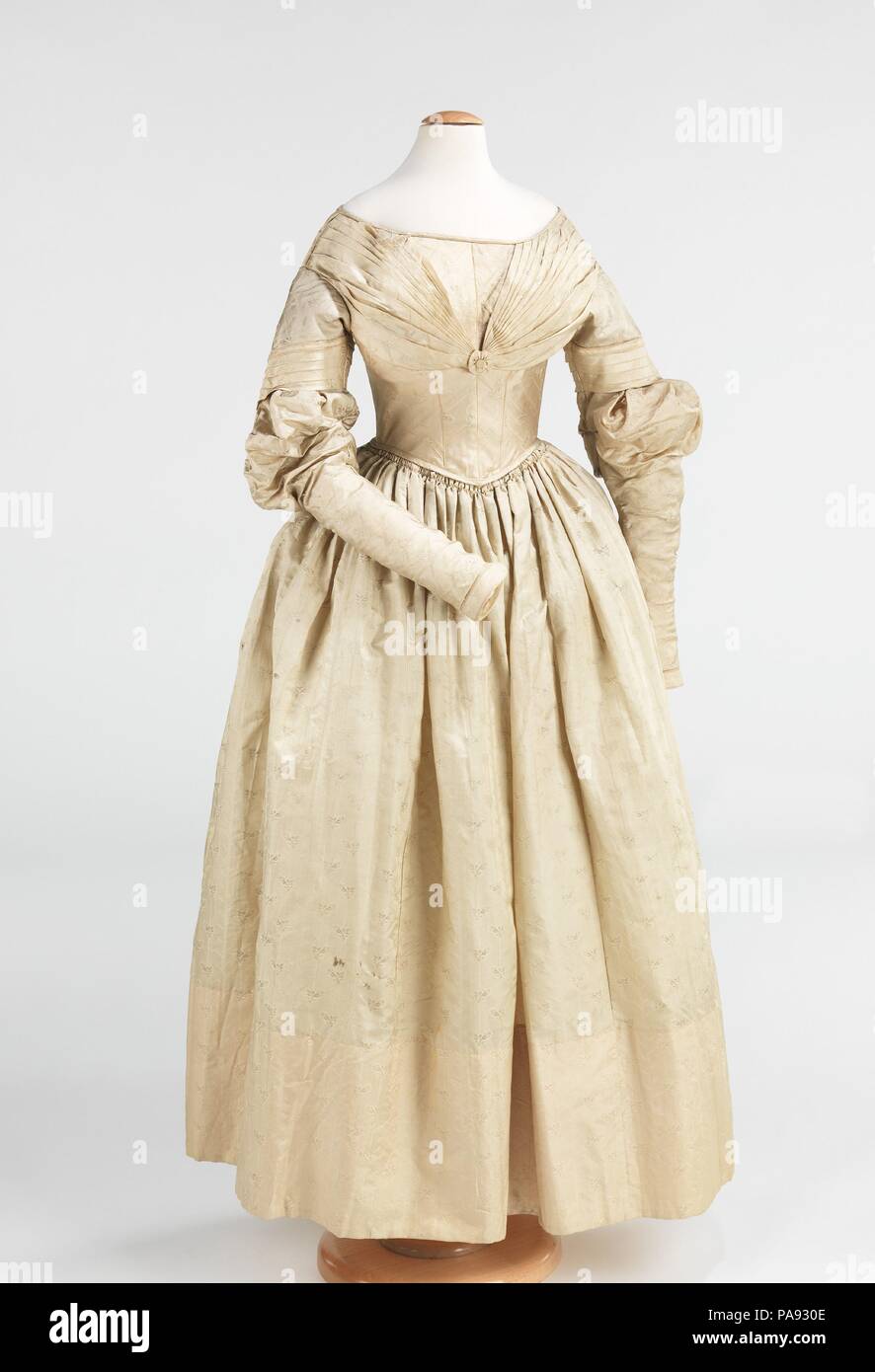 Dress. Culture: American. Date: 1837-40.  This girl's dress is a very good example of the change in style that began in 1837, the year that Queen Victoria became queen. The exaggerated gigot sleeve collapsed in that year, and the sleeve became tight on the upper arm, gradually losing its fullness over the next several years.  This dress shows that transition well and is exemplary of dresses worn by a young teenage girl of the highest style of the period. Museum: Metropolitan Museum of Art, New York, USA. Stock Photo
