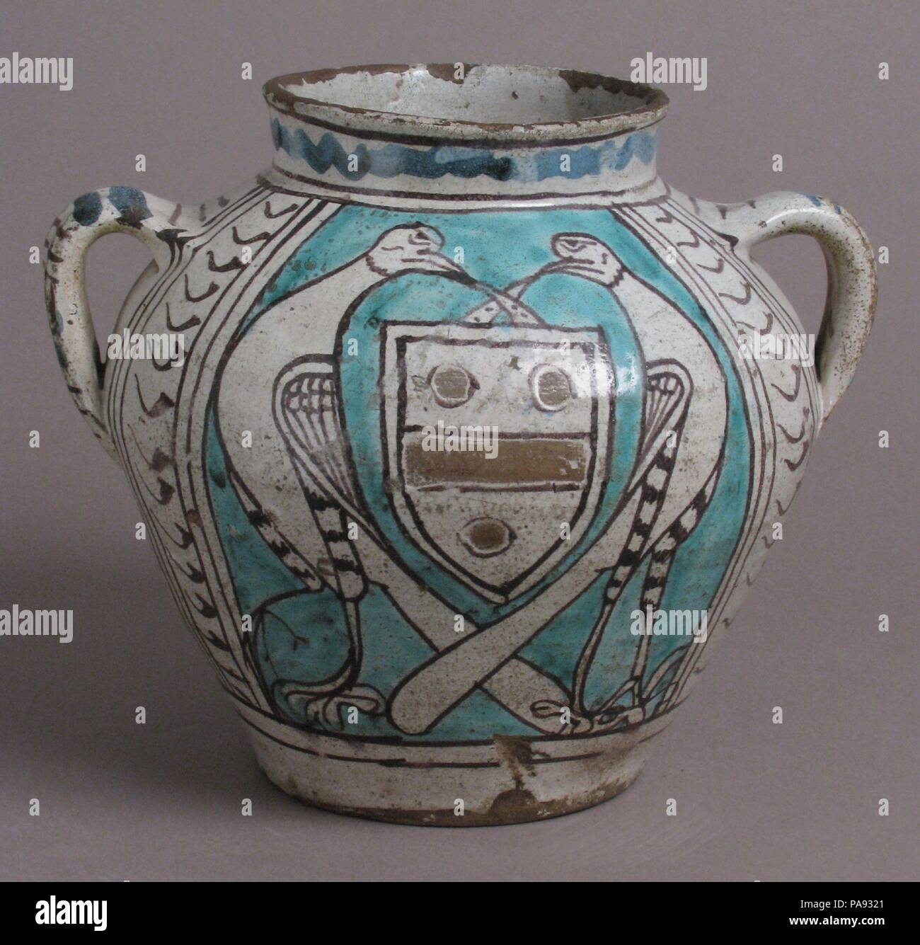 Two-Handled Jar with Birds and a Coat of Arms. Culture: Italian. Dimensions: Overall: 8 1/4 x 9 3/4 x 8 7/16 in. (21 x 24.8 x 21.5 cm). Date: early 1400s.  From 1400 on, finely turned and decorated glazed earthenwares have been associated with Florence. It is unlikely, however, that the earlier of these wares were actually made within the city walls, but rather in outlying Tuscan towns such as Montelupo, situated in the Arno valley between Florence and Pisa. Unlike the earlier Italian earthenwares, the so-called Florentine vessels initiated the use of an all-over white to gray tin-enamel glaze Stock Photo
