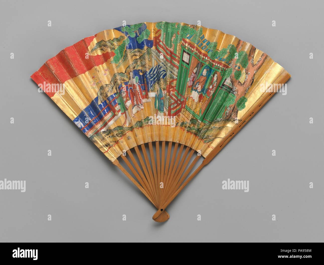 Chukei Fan. Culture: Japan. Dimensions: 13 1/4 × 19 in. (33.7 × 48.3 cm). Date: 19th century.  An important accessory of Noh actors is the chukei fan. In the refined and simplified performances, the fan plays an important role in delineating character. Differentiations in fans include the design, the colors of the ground and the color of the lacquer on the bamboo frame, depending on the particular role being performed. Each side of this fan has a different design, which is richly painted on gold-leafed paper. Cherry blossoms and pine are depicted on one side, and the Queen of the West and the  Stock Photo