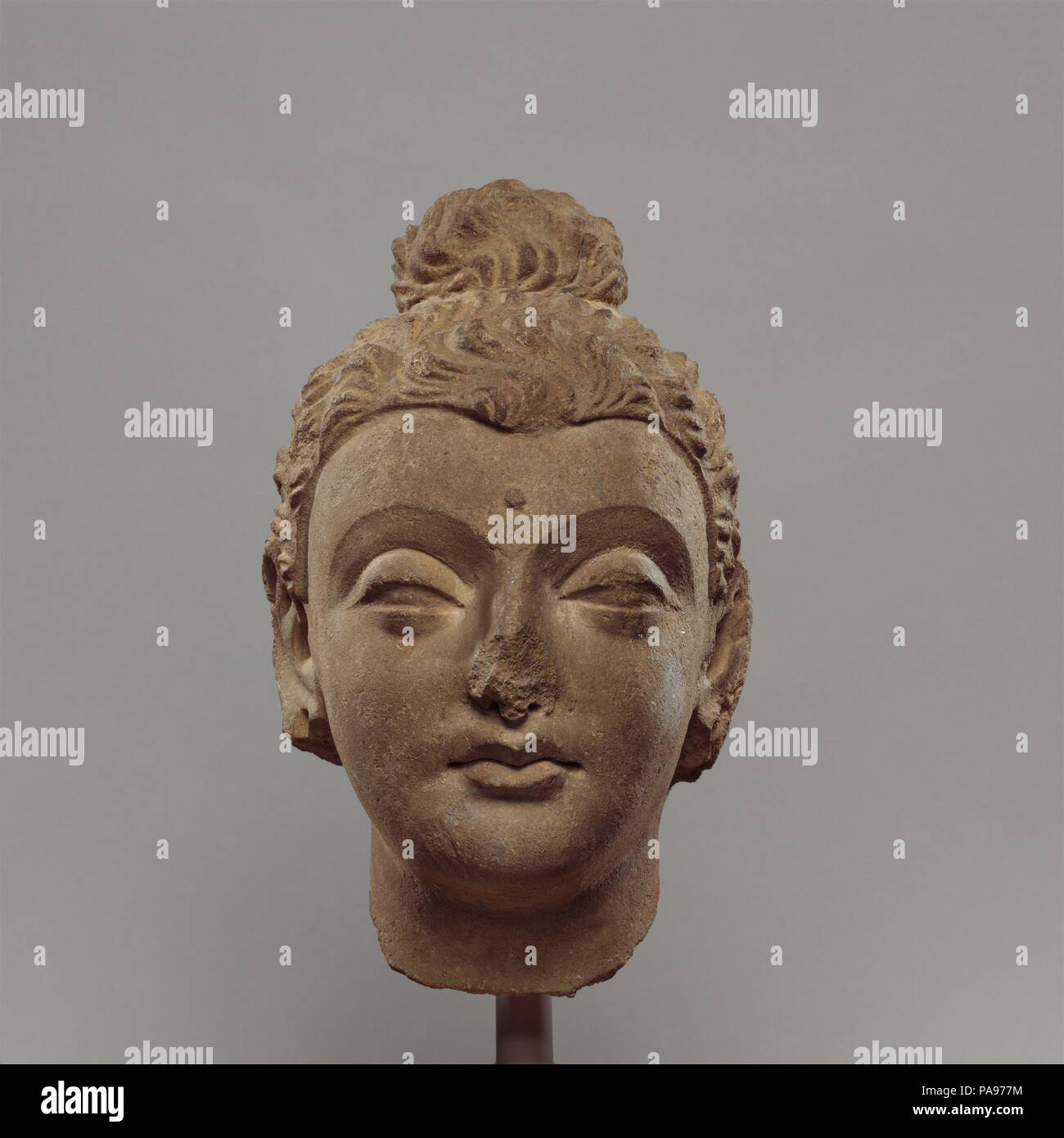 Head of Buddha. Culture: Pakistan (ancient region of Gandhara). Dimensions: H. 7 3/4 in. (19.7 cm); W. 4 1/2 in. (11.4 cm); D. 5 1/8 in. (13 cm). Date: ca. 4th century.  This head shows close stylistic affinities with early stucco production from Gandharan sites at Taxila. The sensitive modeling has an expressive quality that is not seen in the more formal images in stone from this period. Museum: Metropolitan Museum of Art, New York, USA. Stock Photo