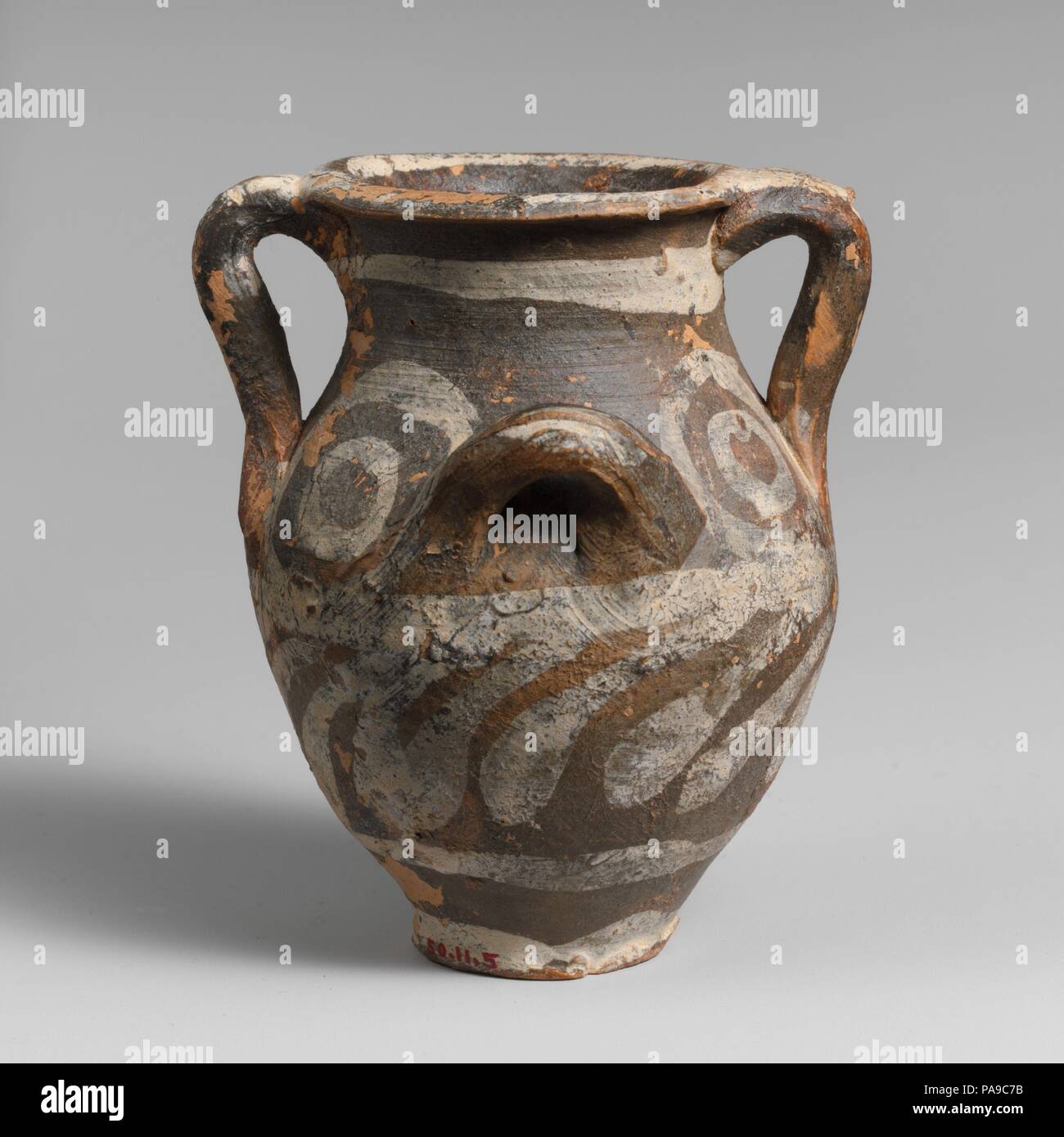Small terracotta jar with four handles. Culture: Minoan. Dimensions: H. 2 7/8 in. (7.3 cm). Date: ca. 1800-1750 B.C..  Handled pot with black and white decoration. Museum: Metropolitan Museum of Art, New York, USA. Stock Photo