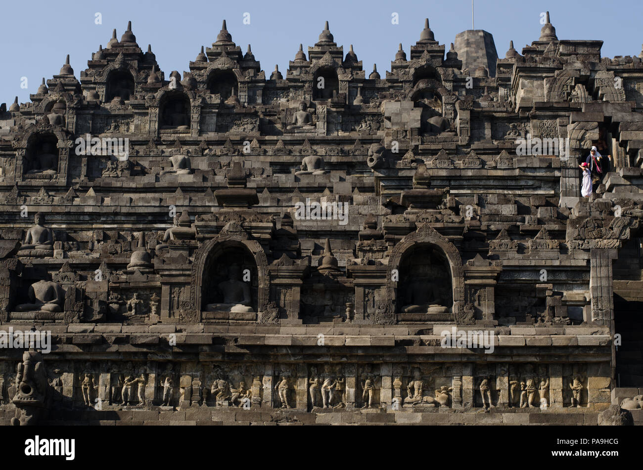 Borobudur temple and bell-enshrined Buddhas looking over the jungle and ...