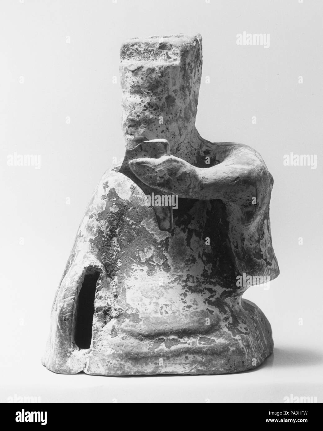 Figure of a Seated Musician. Culture: China. Dimensions: H. 3 1/2 in. (8.9 cm).  The musical instruments depicted among this group of pottery figures (36.12.1, .2, .10-.13, .16) are typical of those used in popular music of the Han period (206 B.C.-A.D. 220). The instruments all had long histories, having existed for centuries, in the case of the zither, or millennia, in the case of the flute (now missing from the figure of the flutist). Museum: Metropolitan Museum of Art, New York, USA. Stock Photo