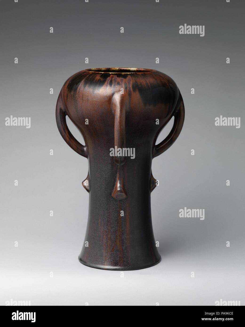 Vase. Culture: French, Paris. Dimensions: Overall (confirmed): 15 15/16 × 10 5/8 × 10 5/8 in., 12.2 lb. (40.5 × 27 × 27 cm, 5.6 kg). Maker: Auguste Delaherche (French, Beauvais 1857-1940 Paris). Date: ca. 1893.  Determined that pottery vessels should be regarded as true works of art, avant-garde ceramicists in France in the last decades of the nineteenth century transformed their craft into an intellectual and emotional endeavor. The pioneers of this revival were Jean Carriès, Ernest Chaplet, Théodore Deck, and Auguste Delaherche. These revolutionary artist-potters embraced artisanal tradition Stock Photo