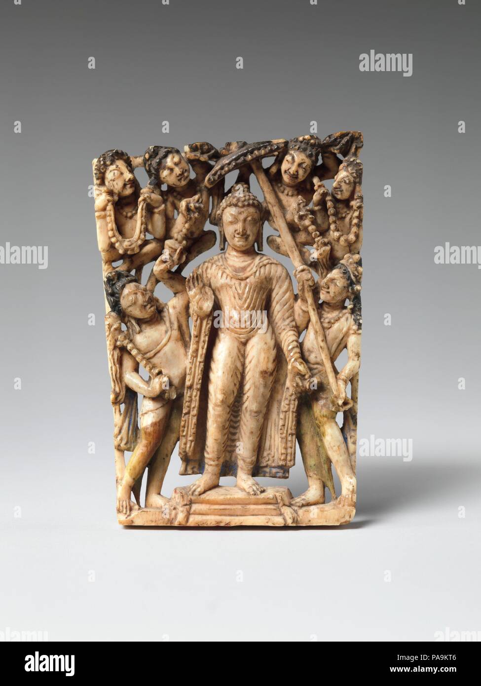 Panel from a Portable Shrine: The Descent of the Buddha from Trayastrimsha Heaven. Culture: India (Jammu and Kashmir, ancient kingdom of Kashmir),. Dimensions: H. 2 1/2 (6.4 cm); W. 1 3/4 in. (4.5 cm). Date: 7th-8th century.  This diminutive panel depicts the Buddha's descent from Trayastrimsha heaven, where he visited to preach the Buddhist gospel (dharma) to his mother, who had died soon after his birth. The three steps below his feet indicate the ladder upon which he descended. This miracle was widely depicted in the early Buddhist world. Here, umbrella and flywhisk bearers attend the Buddh Stock Photo