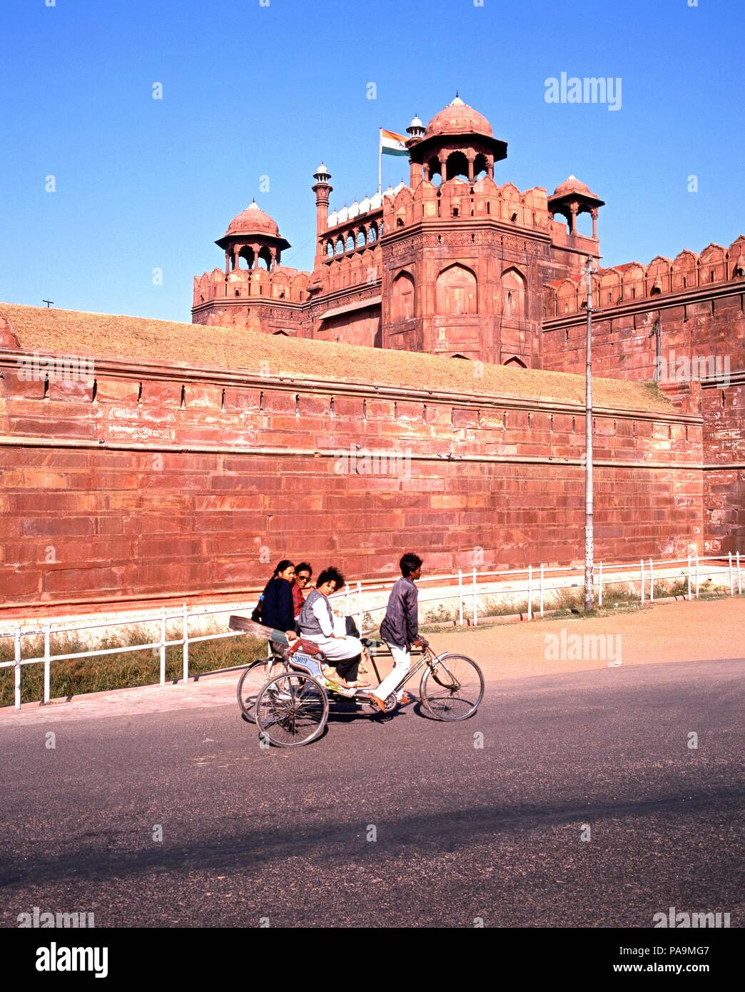 View of the Red Fort with local people on a tricycle in the foreground, Delhi, Delhi Union Territory, India. Stock Photo