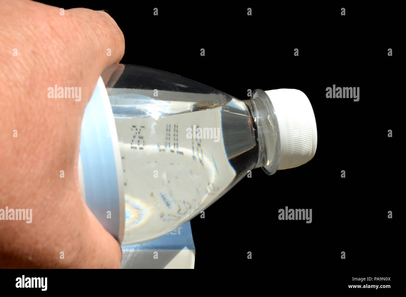 A water bottle can be used as magnifier, here it helps reading the best before date on milk Stock Photo