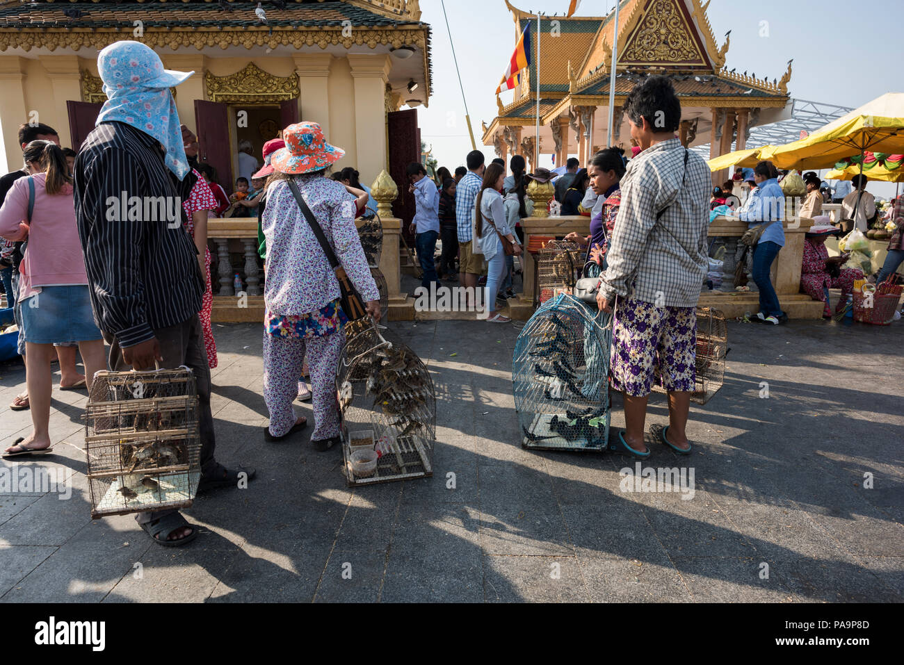 People selling birds to people. They are purchased, released by worshippers after their passage to a temple or a shrine. Phnom Penh, Cambodia Stock Photo