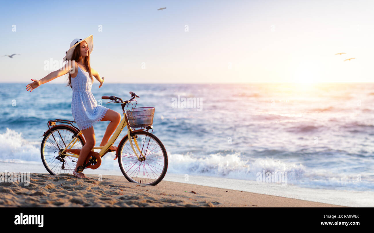 Girl On Bicycle On Beach - Freedom And Carefree Concept Stock Photo