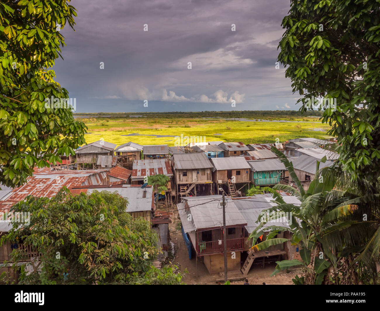 Iquitos, Peru- March 27, 2018: Sunset. View of a floating houses and the Itaya river in poor district of Iquitos, Loreto, Peru.  Amazon Stock Photo