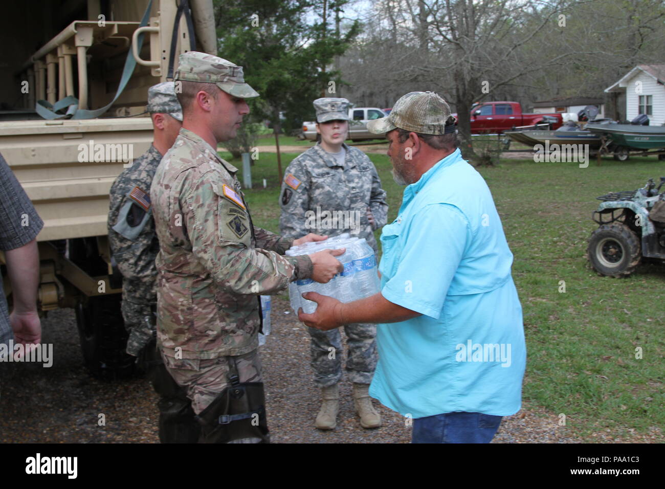 Sgt. David Breaud of Deville, La., with Headquarters and Headquarters Company, 225th Engineer Brigade, assists the Grant Parish Sheriff's Office distribute water to local residents at Latt Lake in Grant Parish, La., March 13, 2016. (U.S. Army National Guard photo by Staff Sgt. Jerry Rushing) Stock Photo