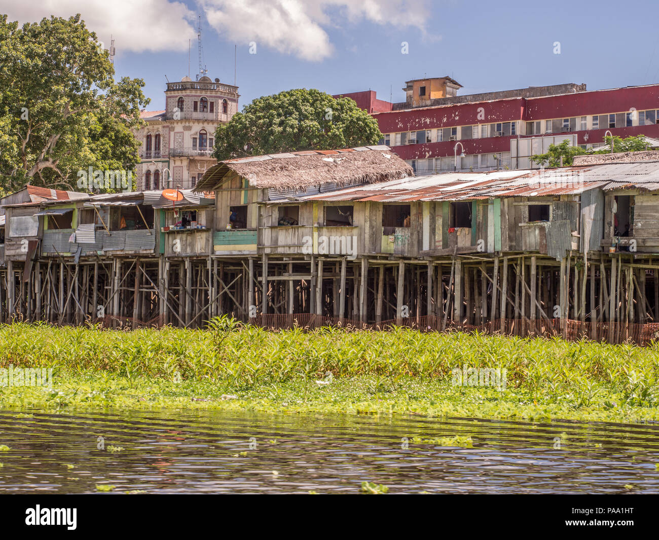 Iquitos, Peru- May 15, 2016: Sunset. View of a floating houses and the Itaya river in poor district of Iquitos, Loreto, Peru.  Amazon Stock Photo