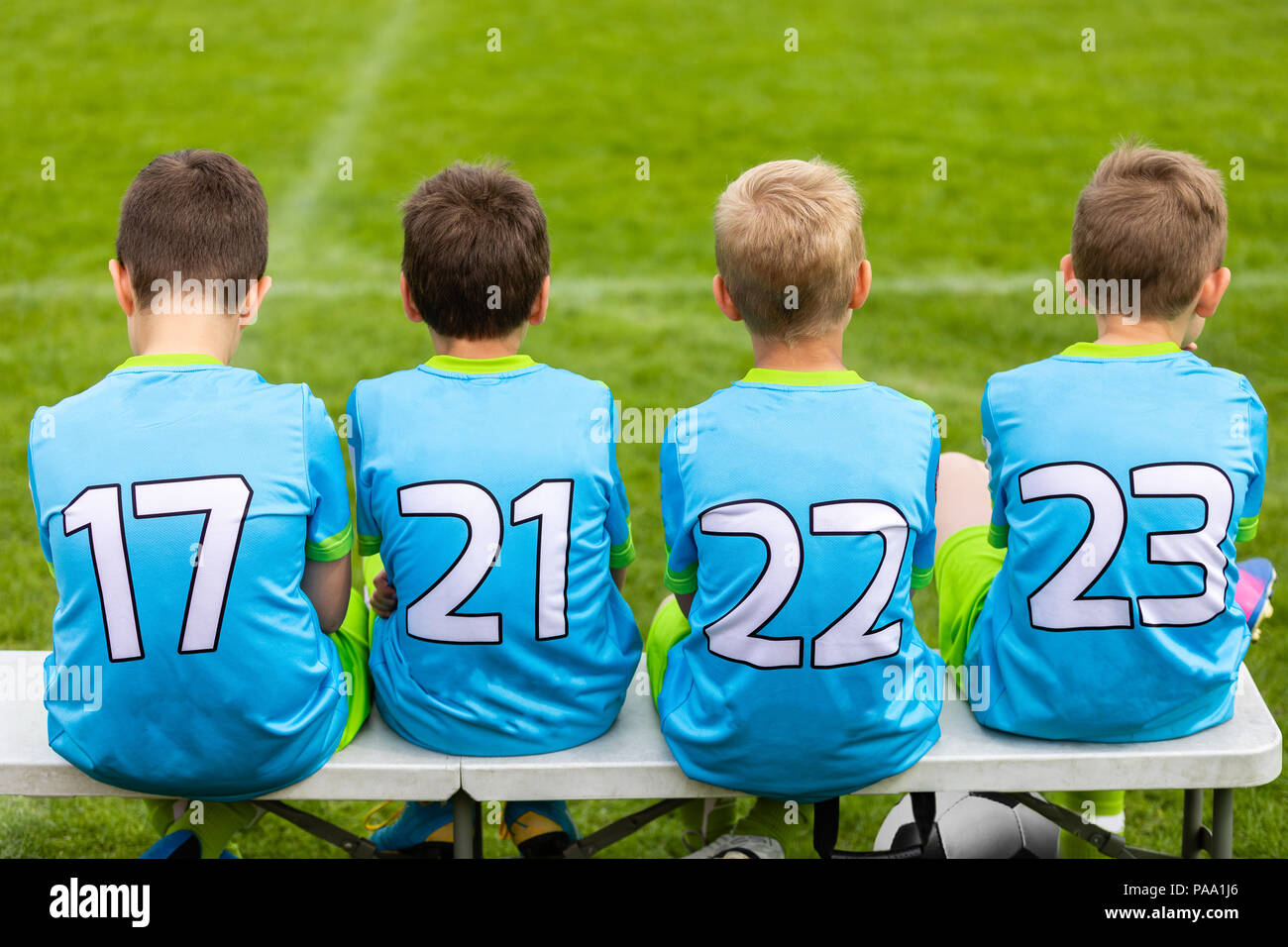 Football soccer game for children. Kids substitute players sitting on a bench. Football sports tournament for young boys Stock Photo