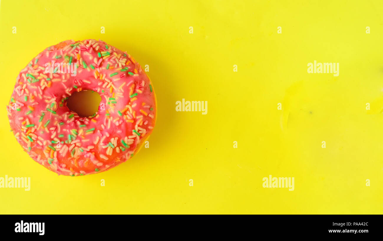 Donuts on pastel yellow background. Sweet donuts.Flatlay.Copyspace right Stock Photo
