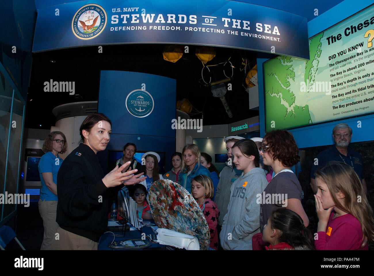 160319-N-MS174-013 NORFOLK, Va. (March 19, 2016) Lt. Lily Daniels, a public affairs officer assigned to U.S. Fleet Forces Command, discusses plastic waste processing with a group of children during the annual Women in Science, Technology, Engineering, and Mathematics (STEM) education event at Nauticus, the National Maritime Center. The Navy employs every means available to mitigate the potential environmental effects of our activities without jeopardizing the safety of our Sailors or impacting our Navy readiness mission. (U.S. Navy photo by Lt. Bobbie A. Camp/Released) Stock Photo