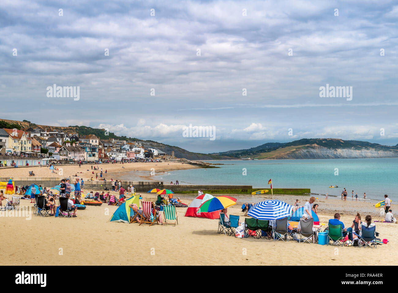 UK Weather - As the good weather continues in the south west of England, holidaymakers enjoy a warm day on the beach at Lyme Regis in Dorset. Stock Photo