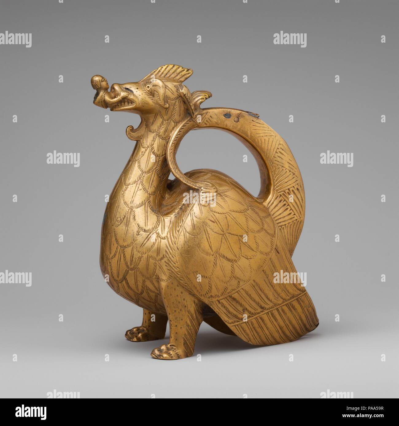 Aquamanile in the Form of a Dragon. Culture: North German. Dimensions: Overall: 8 3/4 x 7 1/4 in., 4.4 lb. (22.2 x 18.4 cm, 2 kg)  Overall PD: 8 3/8 x 4 3/8 x 7 3/16 in. (21.2 x 11.1 x 18.2 cm)  Thickness PD: 3/25 in. (0.3 cm). Date: ca. 1200.  Aquamaniles, which are water vessels used for washing hands, served both liturgical and secular purposes. Those made in the shape of an animal are among the most distinctive products of medieval craftsmen. The most commonly seen zoomorphic aquamaniles are lions, but dragons, griffins, and many other forms were also produced (see acc. nos. 47.101.51, 199 Stock Photo