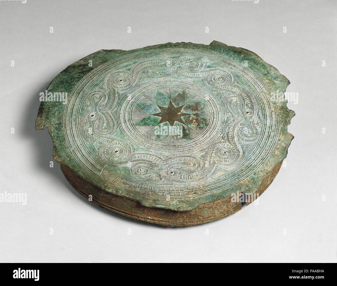 Tympanum of a Pejeng-Type Drum. Culture: Indonesia (Sumba). Dimensions: Diam. 27 15/16  in. (71 cm). Date: ca. 500 B.C.-A.D. 300.  A distinctive style of drum was made in Indonesia that was hourglass-shaped with separately cast and soldered tympanum that overhang the body. In this fragmentary example, the central star design of the top seems to be bordered by stylized feathers and the large outer band of decoration, comprised of a series of interlocking meanders, probably represents birds. Museum: Metropolitan Museum of Art, New York, USA. Stock Photo