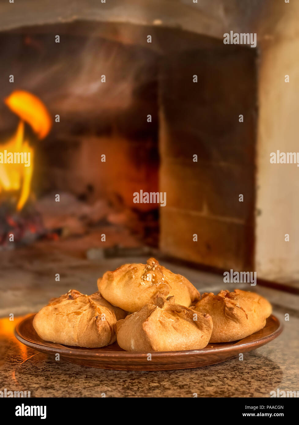 Homemade patties on a round plate against a fire furnace Stock Photo