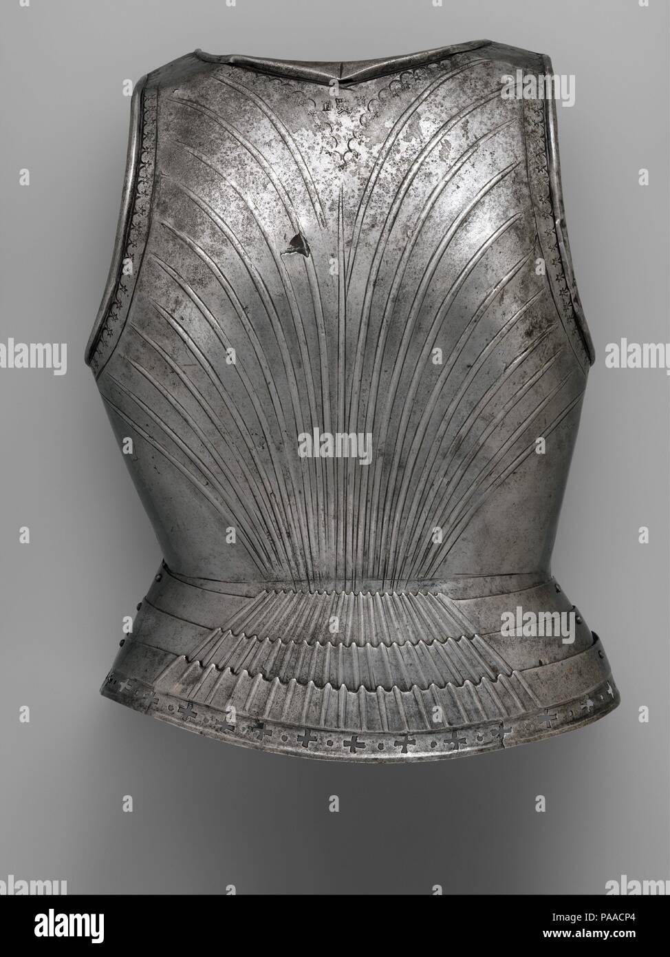 Backplate. Armorer: Probably by Francesco Negroli (Italian, Milan, died before December 1519). Culture: Italian, Milan. Dimensions: H. 19 3/8 in. (49.3 cm); W. 15 1/4 in. (39 cm); D. 6 3/4 in. (17.3 cm); Wt. 5 lb. 6 oz. (2461 g). Date: ca. 1505-10.  Judging by the maker's marks stamped on it, this backplate appears to be the only surviving identifiable work by Francesco Negroli, a member of a leading family of Milanese armorers, which, in the next generation, became internationally renowned for their sculpturally embossed armors <i>all'antica</i> (in the antique style). The backplate is in a s Stock Photo