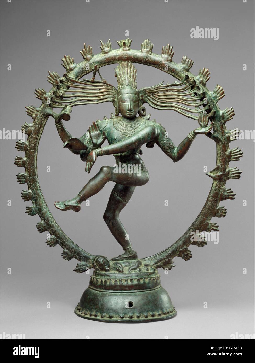 Shiva as Lord of Dance (Nataraja). Culture: Indian (Tamil Nadu). Dimensions: H. 26 7/8 in. (68.3 cm); Diam. 22 1/4 in. (56.5 cm). Date: ca. 11th century.  As a symbol, Shiva Nataraja is a brilliant invention. It combines in a single image Shiva's roles as creator, preserver, and destroyer of the universe and conveys the Indian conception of the never-ending cycle of time. Although it appeared in sculpture as early as the fifth century, its present, world-famous form evolved under the rule of the Cholas. Shiva's dance is set within a flaming halo. The god holds in his upper right hand the damar Stock Photo