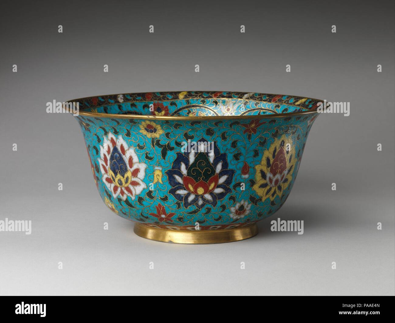 Bowl with the Eight Buddhist Treasures. Culture: China. Dimensions: H. 5 5/8 in. (14.3 cm); Diam. 11 1/2 in. (29.2 cm); Diam. of foot 5 1/2 in. (14 cm). Date: 16th century.  The objects supported by lotus stands at the center of this bowl illustrate a traditional grouping of eight 'treasures'--among them an endless knot, a banner or flag, a conch shell, and a pair of fish--that were introduced with Buddhism and are often found in the later decorative arts. Here, the fish are repeated at the bottom of the bowl, while lotus blossoms, Buddhist symbols of purity, decorate the exterior. The prevale Stock Photo
