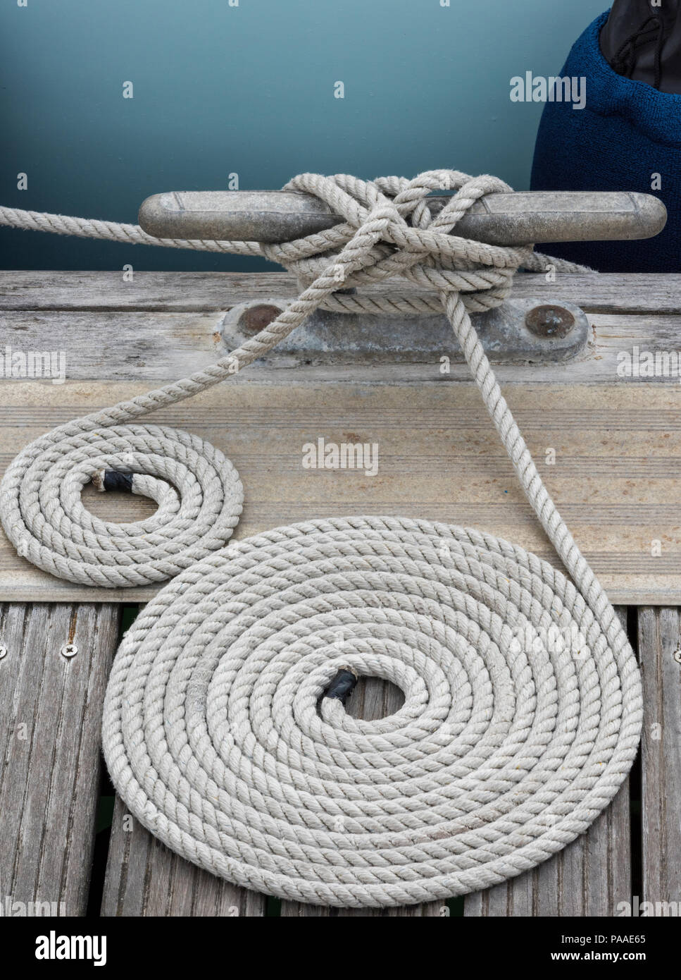 neatly coiled rope on a wooden jetty in a yacht marina. Rope