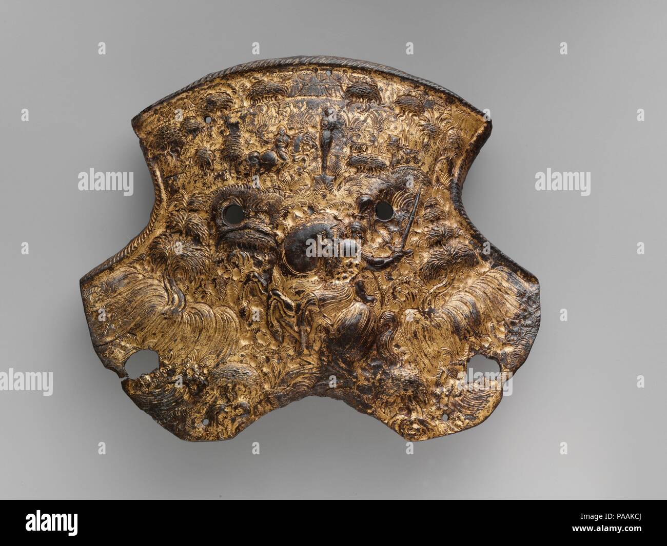 Pommel Plate. Culture: French or Flemish. Dimensions: 8 3/4 x 7 in. (22.2 x 17.8 cm); Wt. 12 oz. (352 g). Date: ca. 1580.  Very few saddle steels are decorated with embossed ornament including figural representations or narrative scenes. The densely detailed style of this pommel plate is a notable example, allowing it to be identified as part of a small group of rare parade armors that were made in France or Flanders in the last quarter of the sixteenth century.  The subjects depicted are derived from Classical history and mythology. In the center of the Museum's pommel plate is a prominent fi Stock Photo