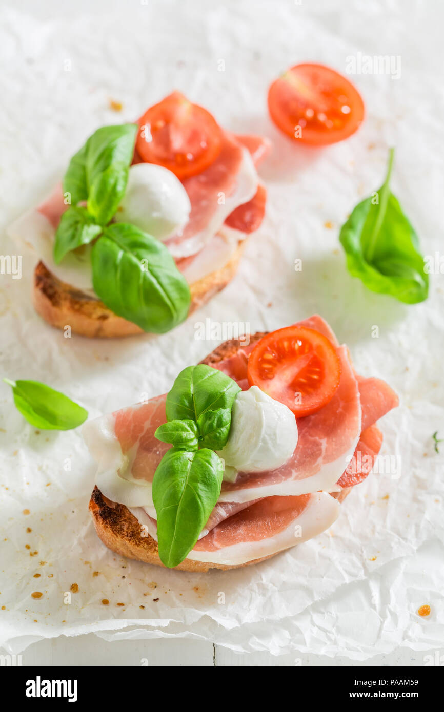 Homemade bruschetta with mozzarella, prosciutto and tomato Stock Photo