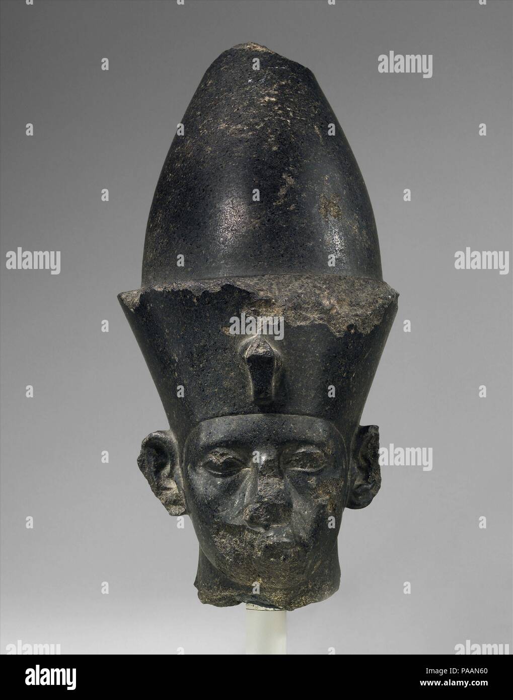 Head of King Amenemhat III. Dimensions: H. 40.6 × W. 18.4 × D. 25.4 cm, 20.9 kg (16 × 7 1/4 × 10 in., 46 lb.). Dynasty: Dynasty 12. Reign: reign of Amenemhat III. Date: ca. 1859-1813 B.C..  Although somewhat battered, this is an impressive image of a pharaoh wearing the double crown of Upper and Lower Egypt. The head is rounder than those depicting Senwosret III; the eyes are less bulbous, and the lids less fleshy. We see, in fact, a portrait of Senwosret's successor Amenemhat III. A piece closely related in style was found at Kom el-Hisn in the western Nile Delta. Like that sculpture the Muse Stock Photo