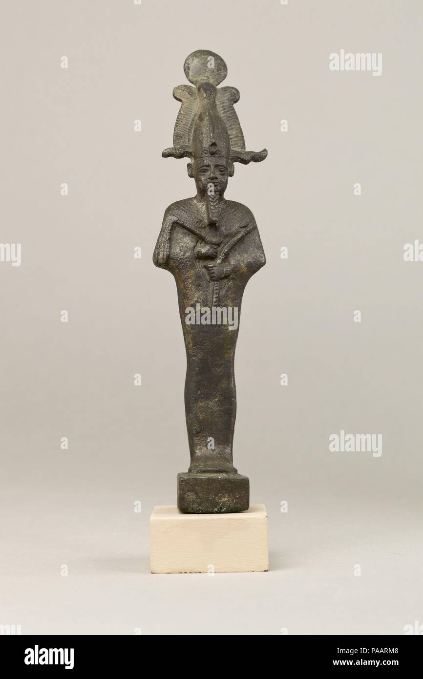 Osiris. Dimensions: H. 17.7 cm (6 15/16 in.); W. 4.5 cm (1 3/4 in.); D. 6.3 cm (2 1/2 in.)  H. (with tang): 19 cm (7 1/2 in.). Date: 664-30 B.C..  Osiris, foremost of the Egyptian funerary gods and ruler of the underworld, stands upright and wears an atef crown with a sun disk on top and ram horns below. His facial features are sensitively modeled with plastic brows and thick, heavy eyelids. His close-fitting mummiform garment has a shallow stiff upper edge along the back of the neck, a feature that occurs with some regularity on this garment, but one with an unclear meaning. His hands and wri Stock Photo