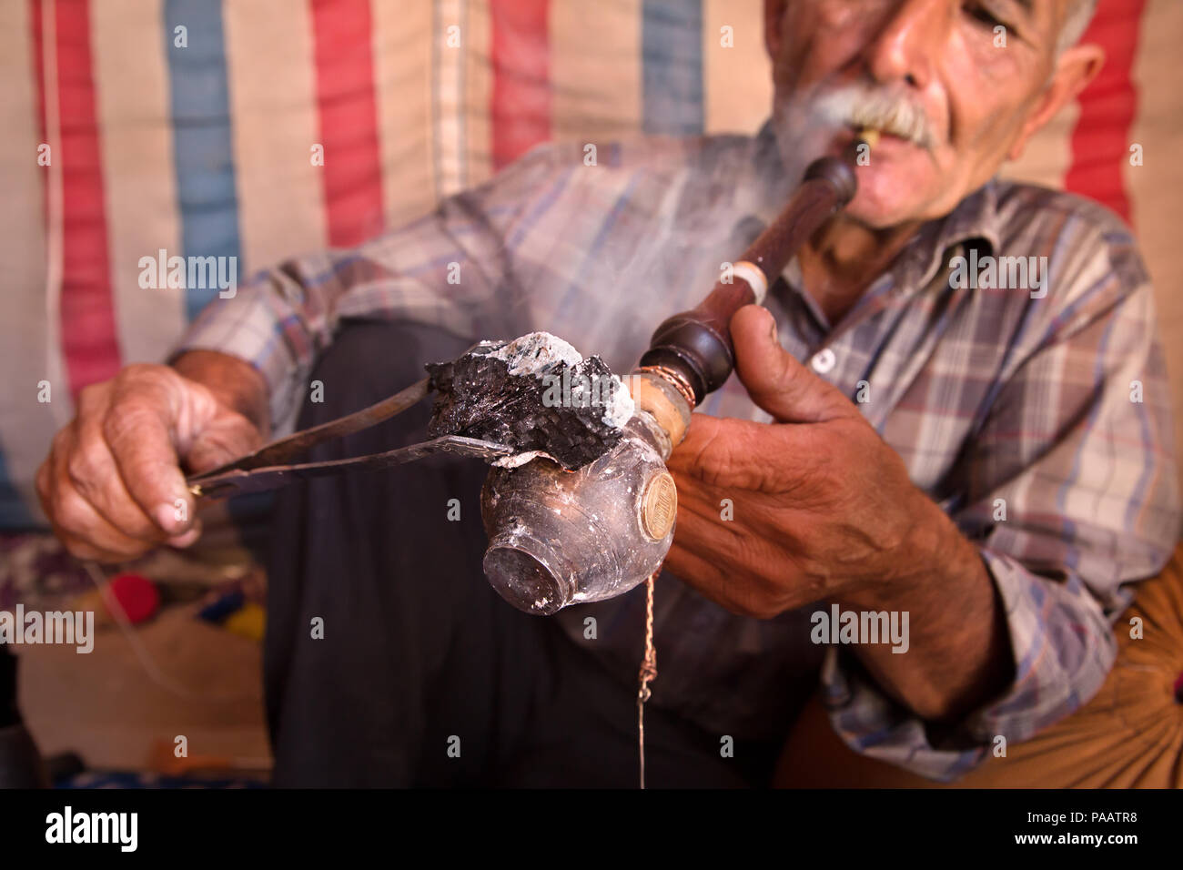 Qashqai man smoking tobacco with traditional pipe,  nomad people, Iran Stock Photo