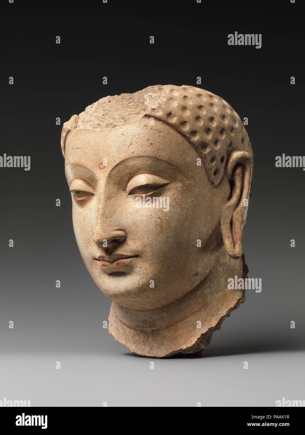 Head of Buddha. Culture: Afghanistan (probably Hadda). Dimensions: H. 7 1/4 in. (18.4 cm). Date: 5th-6th century.  The well-preserved surface and traces of paint provide an idea of what this head looked like when it was being used in worship. The abstracted treatment of the eyes and the intersecting plains defining forehead, eyebrows, and nose are stylistic features shared with imagery produced in north India during the Gupta period. The fact that this north Indian way of presenting the Buddha had penetrated into Afghanistan suggests a shared Buddhist tradition. Museum: Metropolitan Museum of  Stock Photo