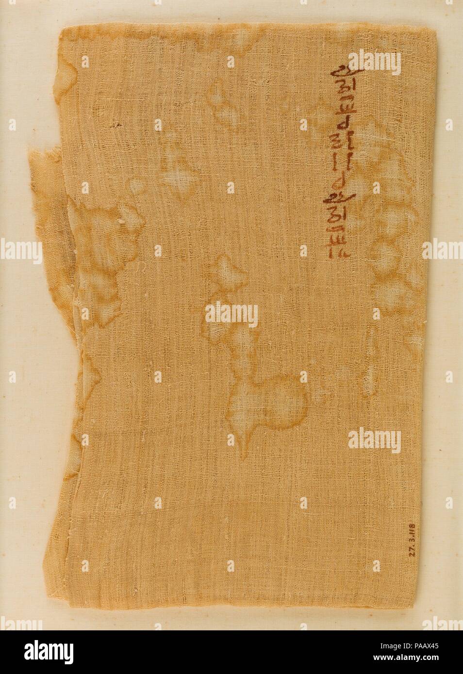 Folded Piece of Linen with Hieratic Inscription. Dimensions: Folded: 25.5 x 17.5 cm (10 1/16 x 6 7/8 in.). Dynasty: Dynasty 12. Reign: Possibly Senwosret I. Date: ca. 1961-1917 B.C..  This folded piece of linen was found in a mass grave of at least fifty-nine soldiers. The bodies showed evidence of violence, and from their wounds it was apparent that they died on the battlefield. Buried with the individuals were small pieces of military equipment such as bows and arrows. The excavator believed that these 'slain soldiers' were connected with a specific historic event that lead to the reunificat Stock Photo
