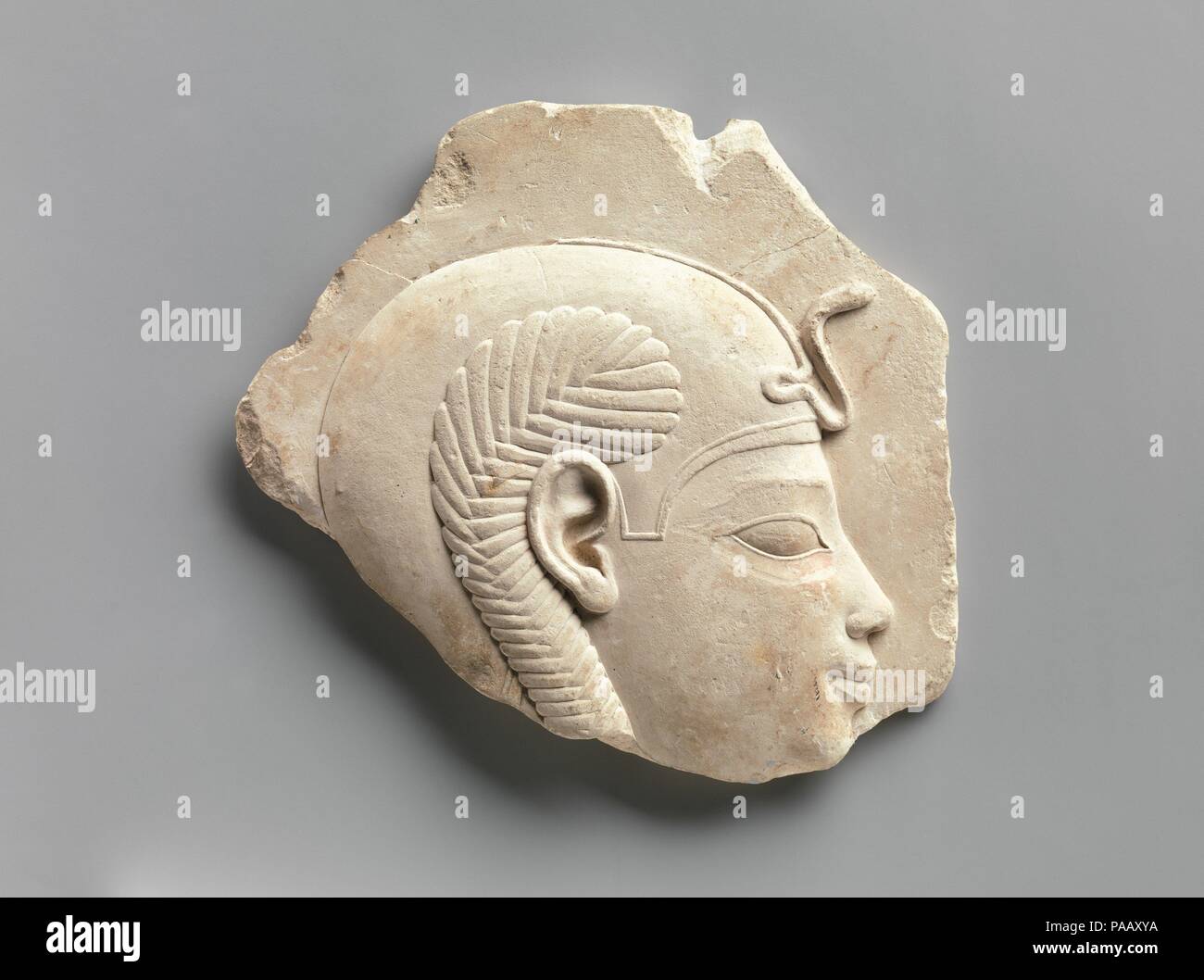 Relief head of a child god. Dimensions: H. 15.3 × W. 17.2 × D. 2 cm (6 × 6 3/4 × 13/16 in.). Date: 400-200 B.C..  Small Late Period and Ptolemaic reliefs or sculptures that depict a subject in a partial or unfinished way but are themselves complete objects constitute a special class of object. Guidelines like those for artists are often prominently exhibited as part of the object, although, in fact, many instances can be noted where the object simply could not serve as a suitable model for a traditional formal Egyptian representation. Personifications of kingship, figures that may represent th Stock Photo