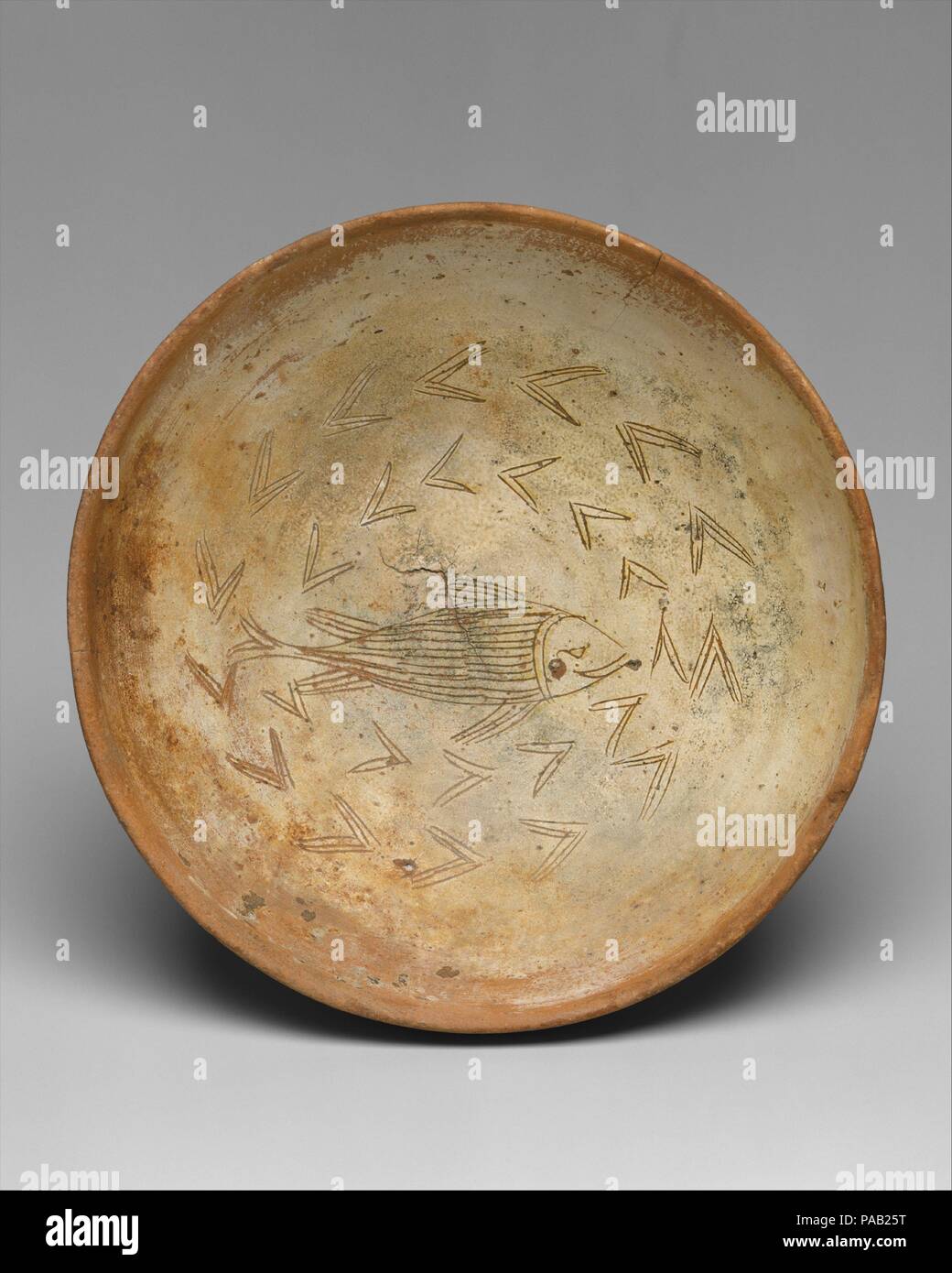 Bowl with Fish. Culture: Byzantine. Dimensions: Overall: 3 9/16 x 10 1/16 in. (9 x 25.5 cm). Date: 1000-1300.  A fish wearing a playful smile swims among reeds. Fishing was an important trade in the Byzantine Empire. Large fish were often centerpieces of banquets and were given as valuable gifts. Museum: Metropolitan Museum of Art, New York, USA. Stock Photo