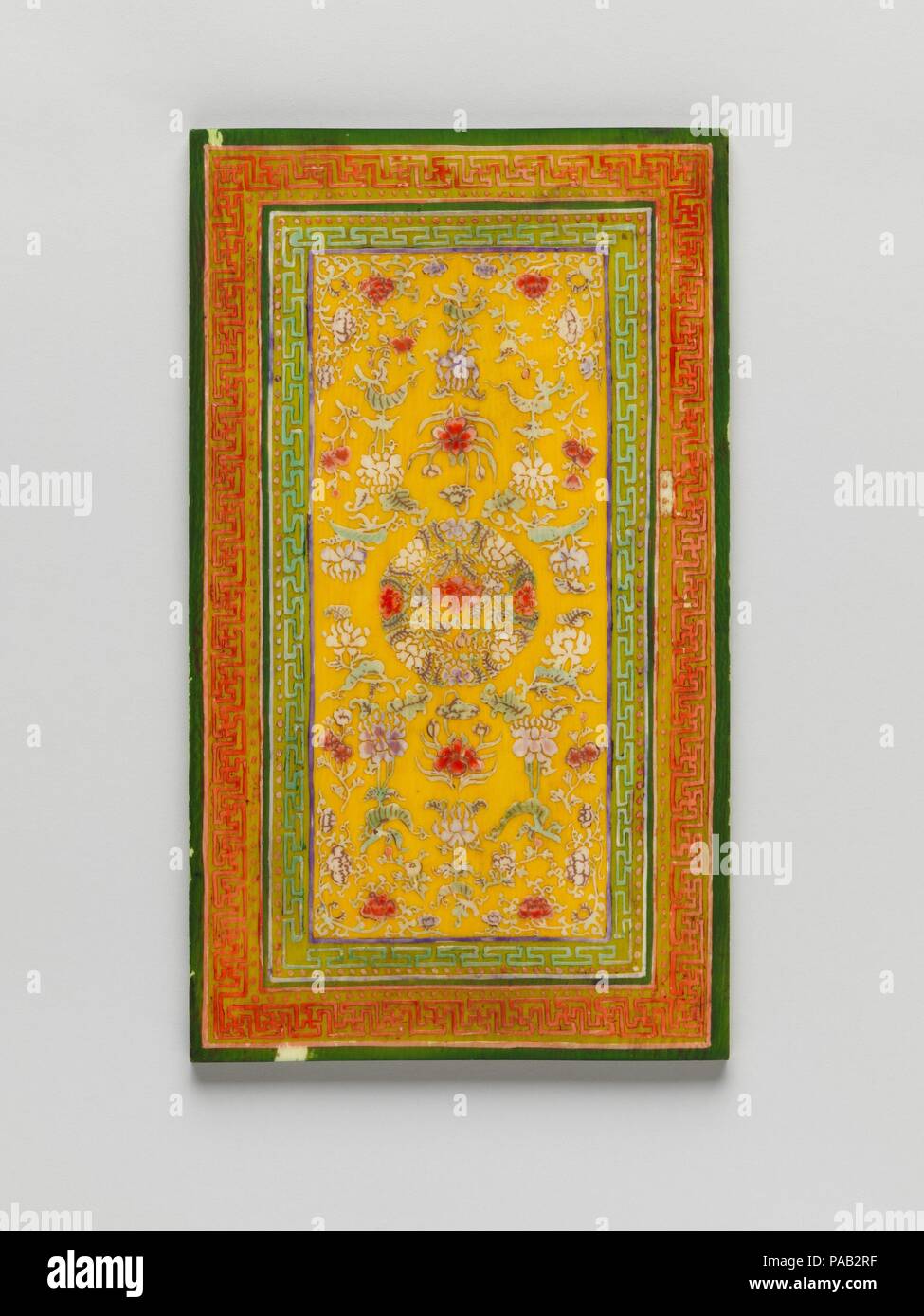 Tablet with Design for a Carpet. Culture: China. Dimensions: 3 15/16 x 6 5/8 in. (10 x 16.8 cm).  The use of a precious material such as ivory to make a model of a carpet was typical of the famously extravagant Qianlong Emperor. The design of a roundel filled with flowers and surrounded by floral scrolls can also be found in porcelains and other objects from the eighteenth century. Museum: Metropolitan Museum of Art, New York, USA. Stock Photo