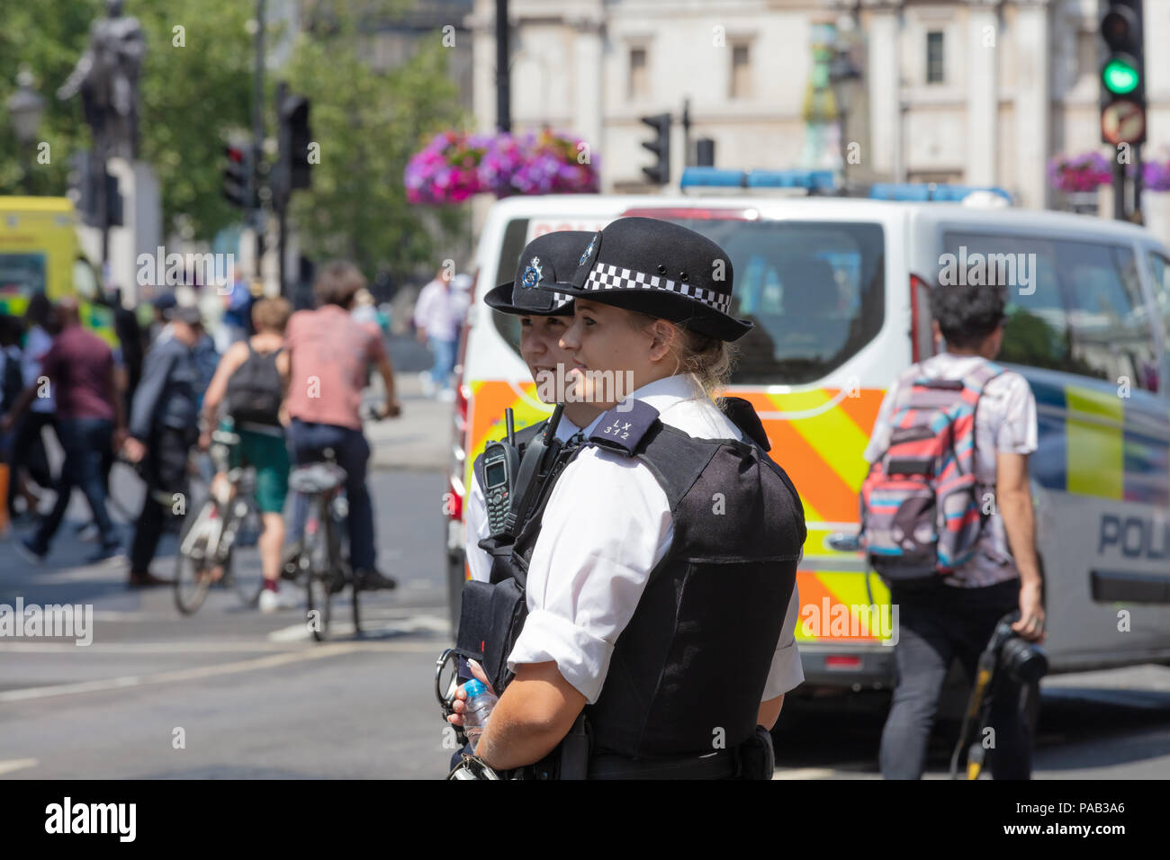 London, England, UK; 13th July 2018; Two Female Metropolitan Police Officers in the Street.  Unfocused Police Van Behind Stock Photo