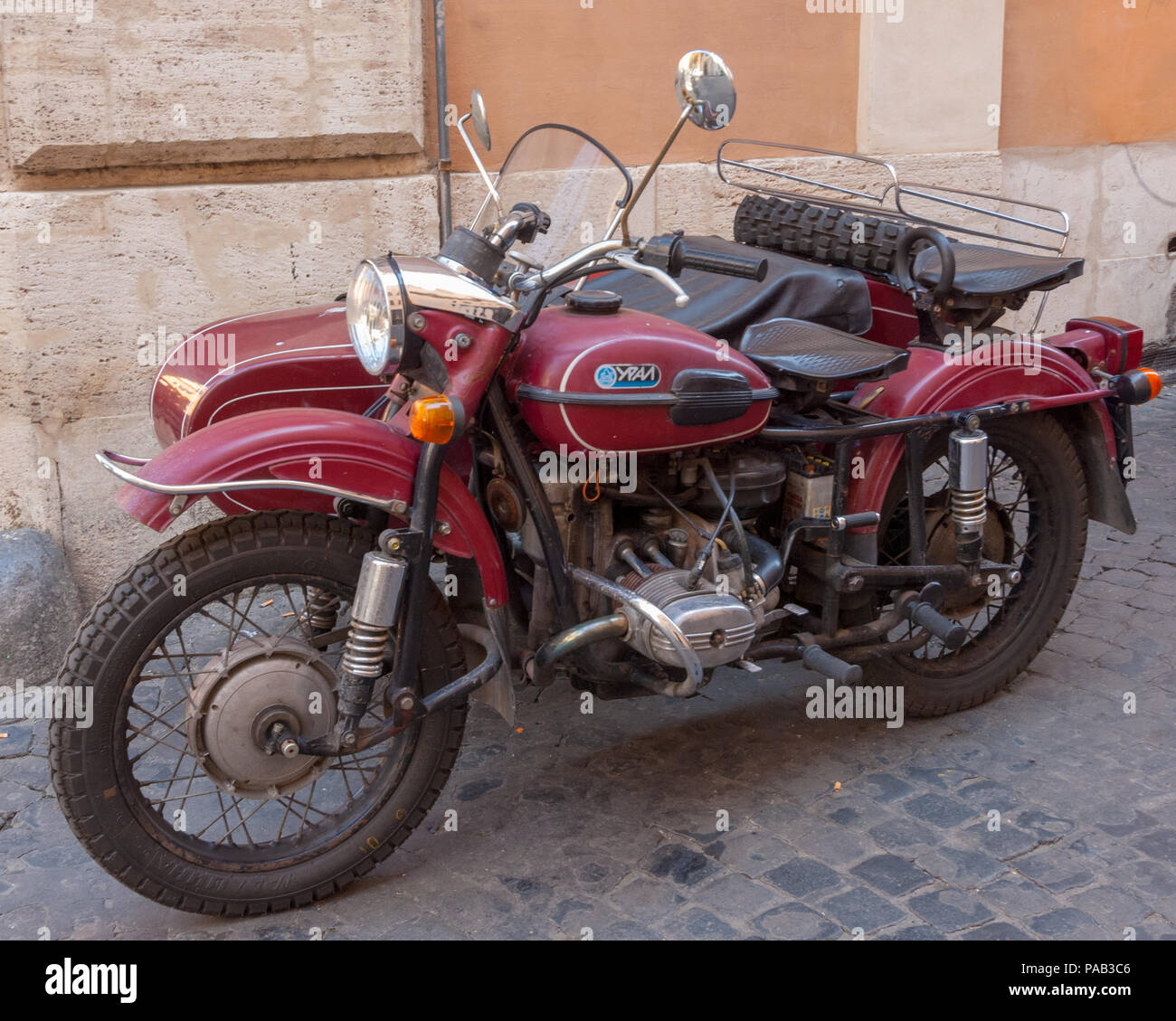 A Ural Ypan Russian motorcycle and side car looking good for its age in a Rome side street. Stock Photo